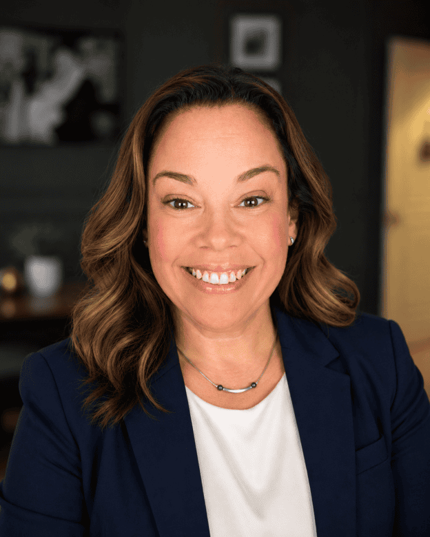 Friendly woman in professional attire smiling, representing GMFS Partners mortgage and home loan solutions.