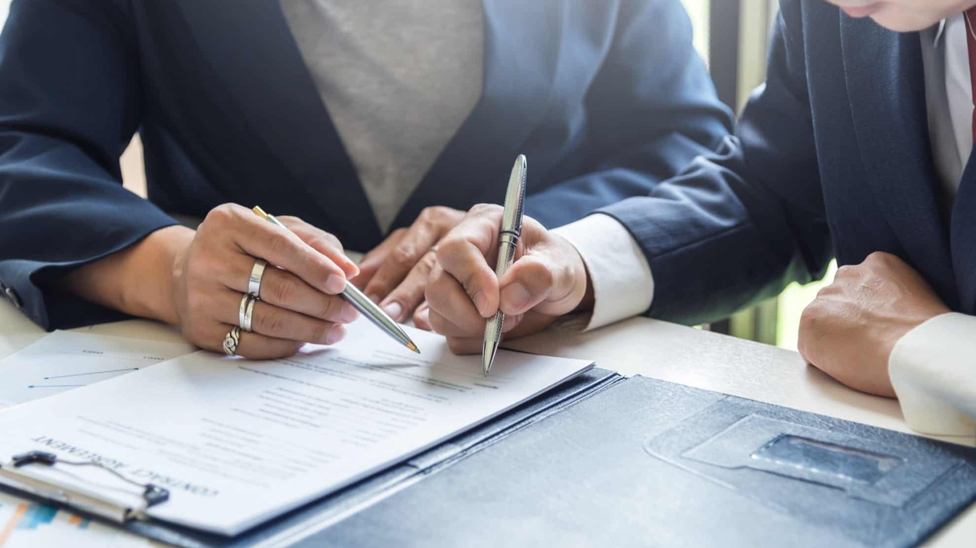 Two people signing documents