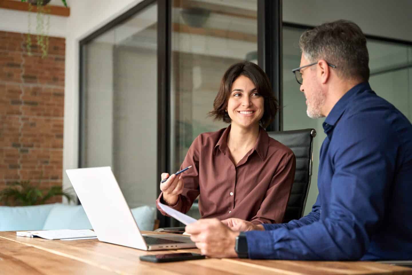 Competent mortgage professionals discussing real estate financing options at a modern office, emphasizing trusted home loan services and mortgage solutions offered by GMFS Partners.