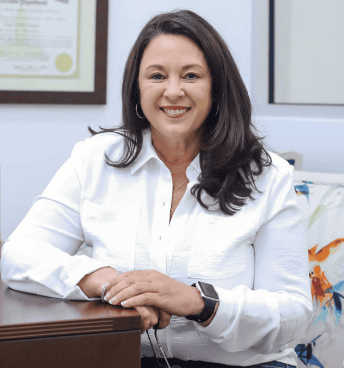 Professional woman smiling in an office, representing GMFS Partners' builder sales support services for home builders.